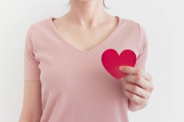 Pembe elbiseli kadın, kalp şeklini aşk ve sevgililer günü konseptinde gösteriyor..