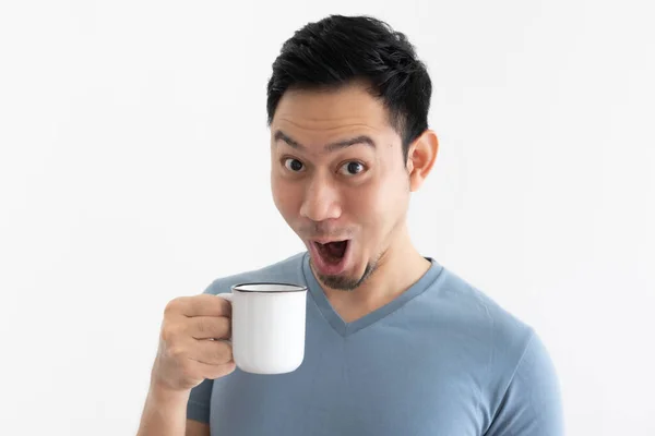 Humour wow visage de l'homme en t-shirt bleu boit café de tasse blanche. — Photo