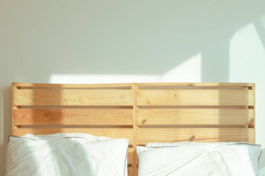 Tavan arası beyaz yatak odası, yumuşak güneş ışığı, kış sabahı..