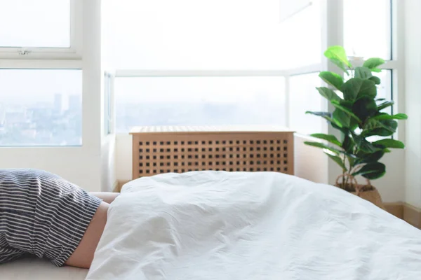 Тело часть женщины спать на белой кровати в яркое утро. — стоковое фото