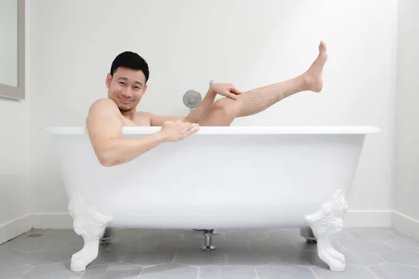 Funny man trying to be sexy in white bathtub. Concept of fun and relax. — Stock Photo, Image