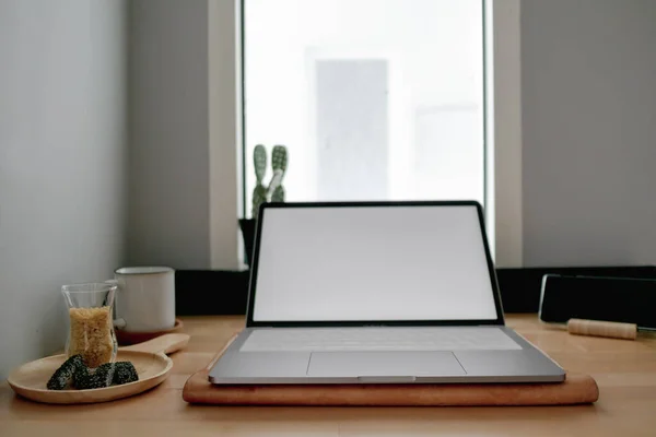 Blanco portátil pantalla vacía en un escritorio de madera. — Foto de Stock