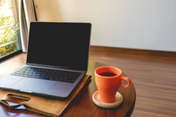 Kaffeetasse und Laptop auf dem Tisch im Café. — Stockfoto