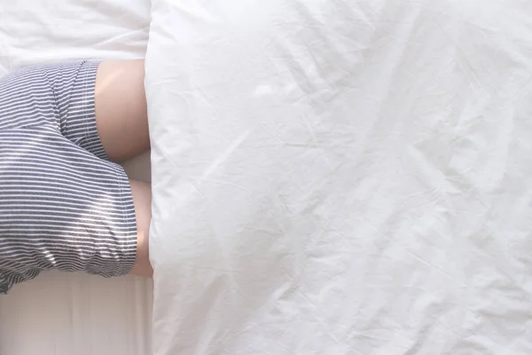 Parte do corpo da mulher dormir na cama branca na manhã brilhante. — Fotografia de Stock