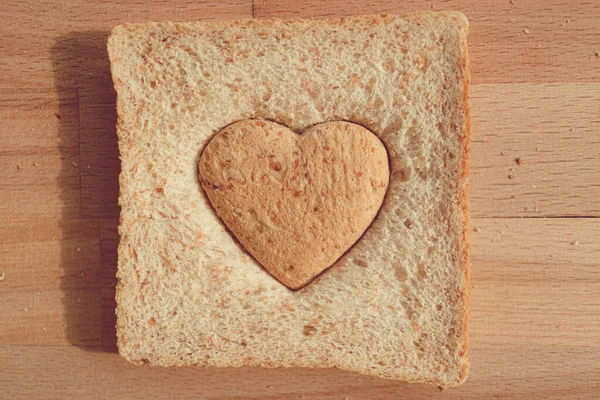 Pão cortado como forma de coração. Conceito de amor e cuidado no dia dos namorados. — Fotografia de Stock