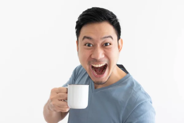 Funny wow cara de hombre en camiseta azul bebe café de taza blanca. — Foto de Stock