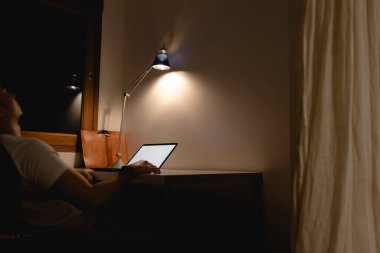 Adam geceleri dizüstü bilgisayarla masa başında çalışırken uyuyakalıyor..