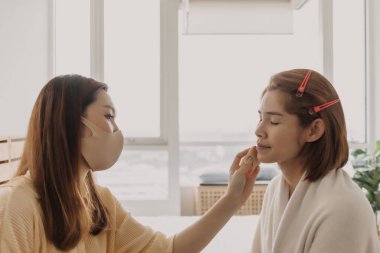 Makyajcı kadın işte ve modeline makyaj yapıyor..