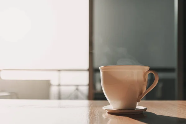 Heiße Tasse Getränk auf dem Tisch im Sonnenlicht des ruhigen Morgens. — Stockfoto