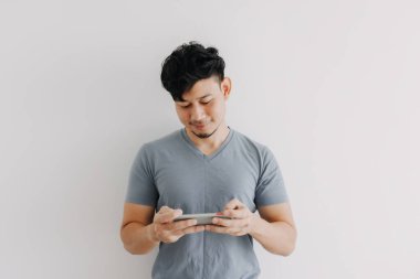 Mutlu adam beyaz arkaplanda izole edilmiş çevrimiçi mobil oyun oynuyor.