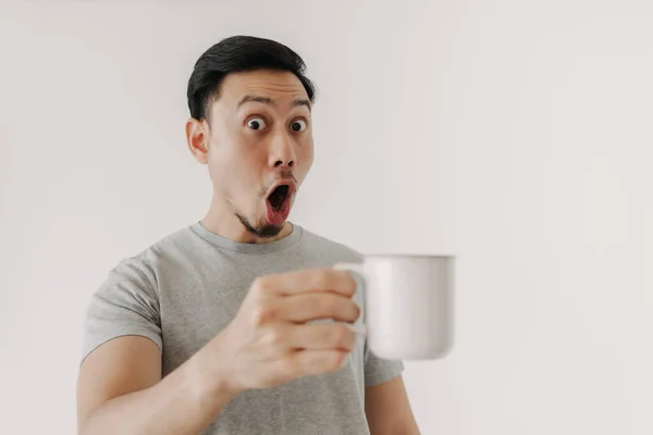 Überraschtes Gesicht des Mannes trinkt eine Tasse Kaffee isoliert auf weißem Hintergrund. — Stockfoto