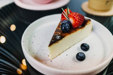 Beyaz tabakta servis edilen yanmış çilekli kek..