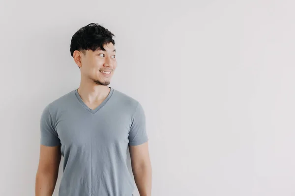 Cara feliz del hombre asiático mira un espacio vacío aislado en la pared blanca — Foto de Stock