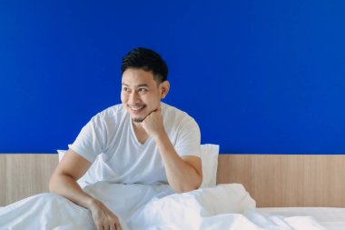 Mutlu adam mavi fotokopi arkaplanda yatağında uyanıyor..