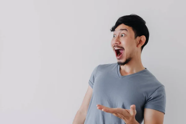 Schockiertes und überraschtes Gesicht eines Mannes in blauem T-Shirt auf weißem Hintergrund. — Stockfoto