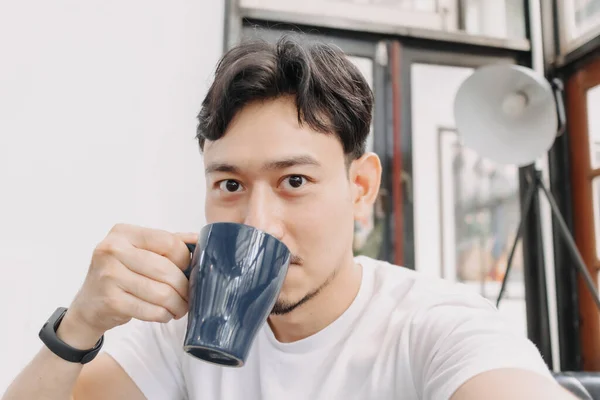 L'uomo felice sta bevendo caffè caldo della bevanda nel caffè. — Foto Stock