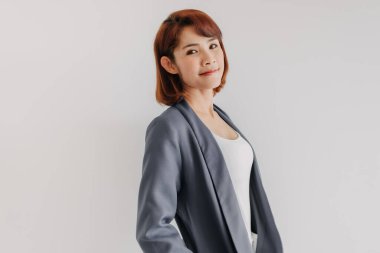 Beyaz ve mavi takım elbiseli ve beyaz arka planlı bir iş kadını..