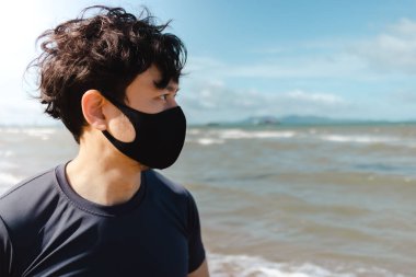 Adam yaz sabahı plajda maskeyle koşuyor..