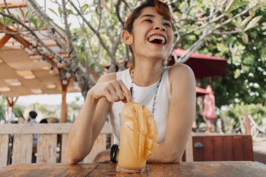 Mutlu kadın yaz günü mango suyu içiyor..