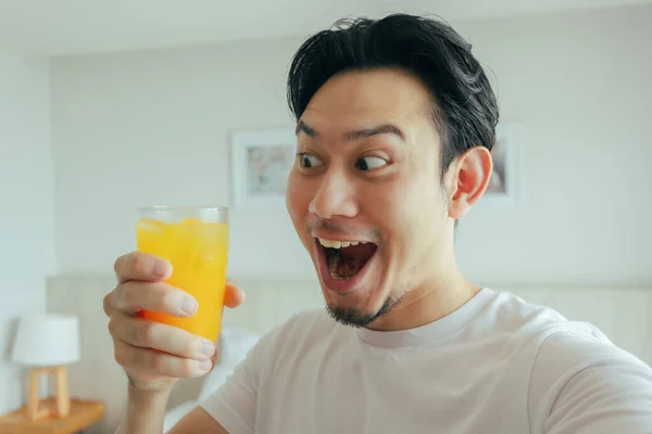 Visage drôle de l'homme boire du jus d'orange frais à l'hôtel pour les vacances d'été. — Photo