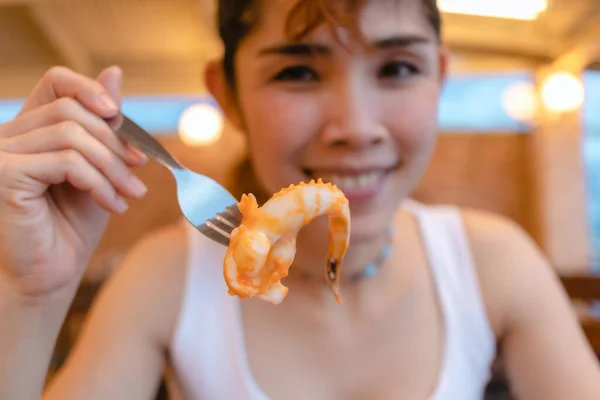 Glückliche Frau isst gerne Tintenfisch in den Sommerferien. — Stockfoto