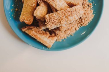 Mavi seramik tabakta servis edilen barbekü aromalı tost çubukları..