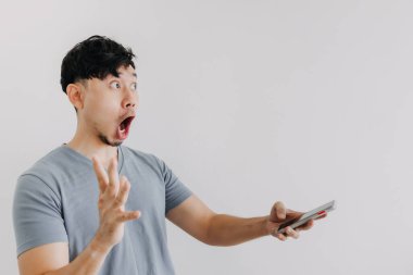Adamın şaşırmış yüzü beyaz duvarda izole edilmiş bir akıllı telefon tutuyor..