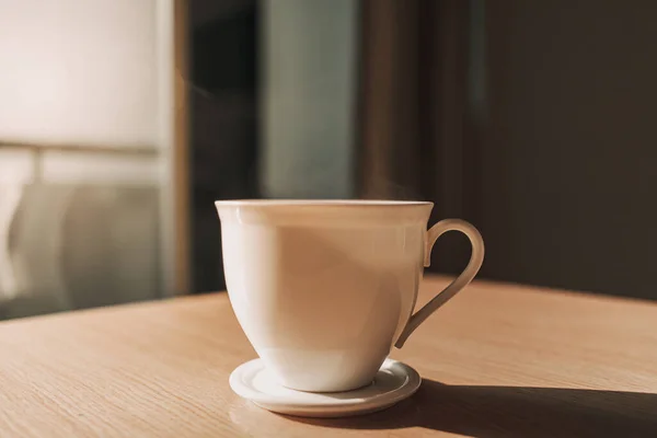 Copa caliente de bebida en la mesa a la luz del sol de la mañana tranquila. — Foto de Stock