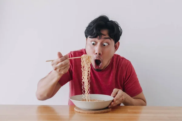 Wow und überrascht lustiges Gesicht des Mannes essen Instant-Nudeln. — Stockfoto