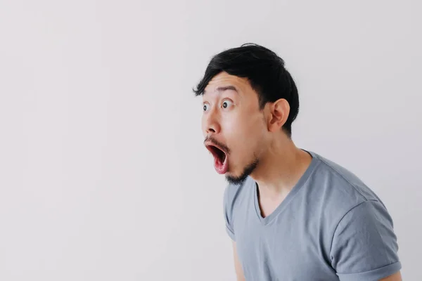 Shocked and surprised face of man in blue t-shirt isolated on white background. — Stock Photo, Image