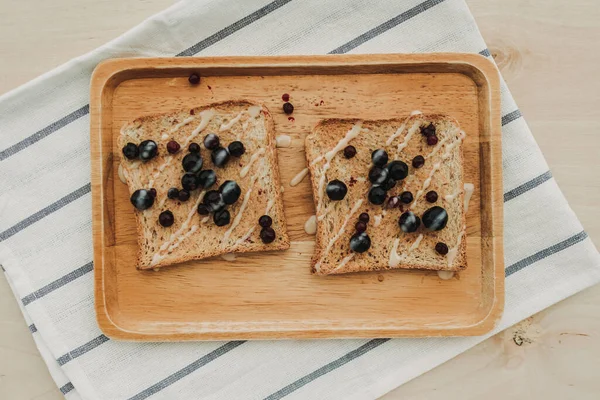 Bayas mixtas pan tostado servido en plato de madera. — Foto de Stock