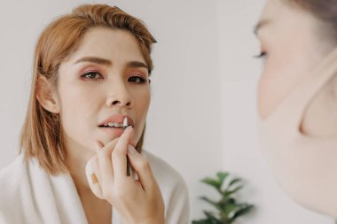 Makyöz müşterilere ruj sürüyor..