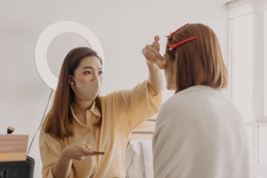 Makyajcı kadın işte ve modeline makyaj yapıyor..