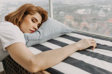 Havalı bir kadın dinleniyor ve evinden manzarayı seyrediyor..