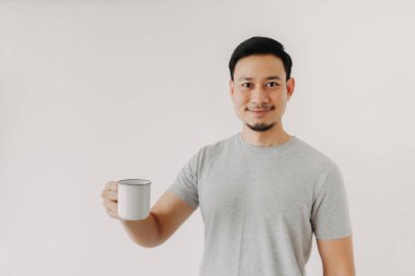 Mutlu adam beyaz arka planda izole edilmiş bir fincan kahve tutuyor..