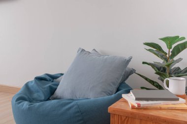 Ahşap zemini ve temiz beyaz duvarı olan temiz bir oturma odasında fasulye torbası..