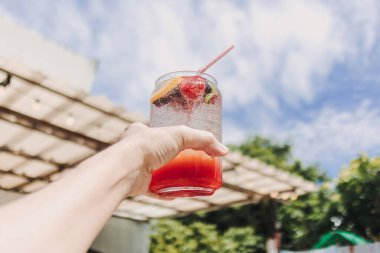 Yazın güneşli gökyüzüne karşı karışık meyveli pembe İtalyan gazozu.