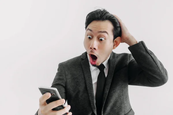 Wow i zaskoczony twarz biznesmena używać aplikacji handlowej na telefon. — Zdjęcie stockowe