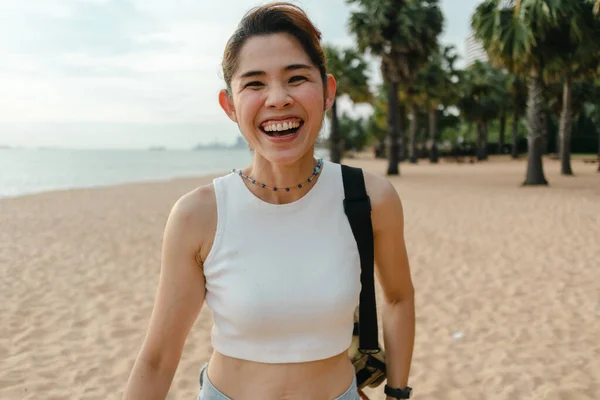 Vrolijke vrouw lachen en lopen op het strand. — Stockfoto