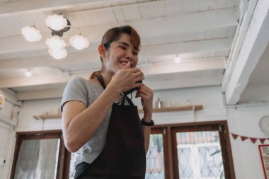 Mutlu kadın kafesi ve maske takan restoran sahibinin portresi..