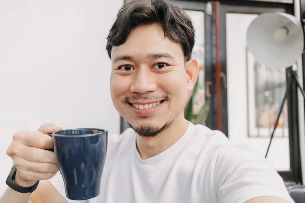 L'uomo felice sta bevendo caffè caldo della bevanda nel caffè. — Foto Stock