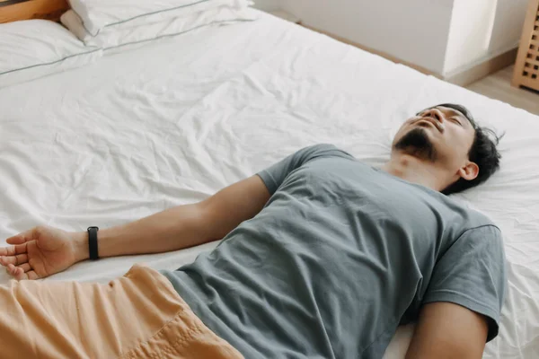 피곤 한 남자가 침대에 누워 에너지가 없어 지고 있습니다. — 스톡 사진