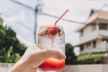 Yazın güneşli gökyüzüne karşı karışık meyveli pembe İtalyan gazozu.