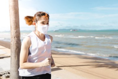 Sıcak yaz sabahında sahilde koşan bir kadın..