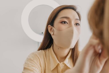 Makyajcı kadın işte ve modeline makyaj yapıyor..