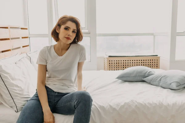 Cool εμφάνιση γυναίκα σε λευκό t-shirt και jean χαλαρώστε στο δωμάτιό της. — Φωτογραφία Αρχείου