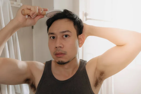 Man is combing his hair in the bathroom. — Stock Photo, Image