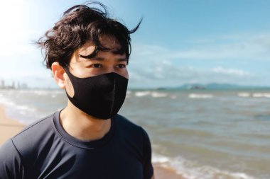 Adam yaz sabahı plajda maskeyle koşuyor..