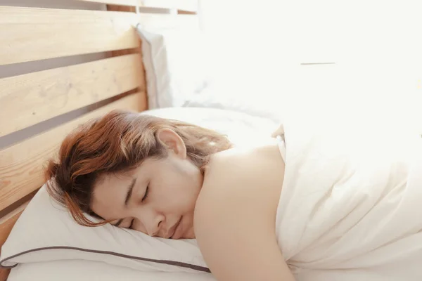 Κοντινό πλάνο της γυναίκας κοιμάται στο λευκό κρεβάτι της. Έννοια της υπνηλίας. — Φωτογραφία Αρχείου