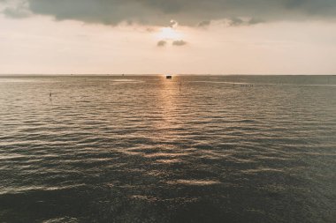 Gün batımının ve denizin ortasında küçük bir balıkçı kulübesi..